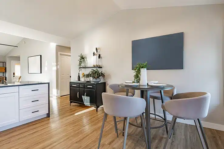Comprar muebles sin un plan suele salir caro (aunque no lo parezca) Comedor pequeño integrado junto a la cocina con mesa redonda y sillones - planificar la compra de muebles