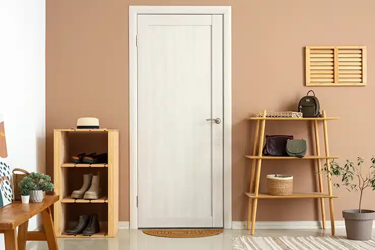 El recibidor: el gran olvidado que cambia la primera impresión de tu casa Recibidor pequeño con zapatero y estantería de madera junto a la puerta