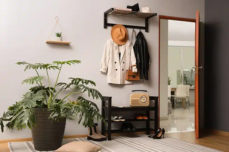 El recibidor: el gran olvidado que cambia la primera impresión de tu casa Recibidor con perchero de pared, banco zapatero y plantas decorativas