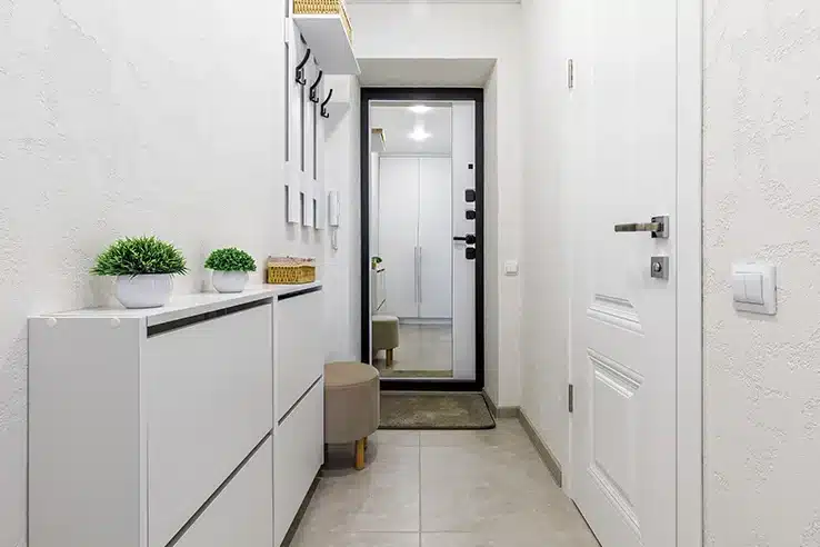 El recibidor: el gran olvidado que cambia la primera impresión de tu casa Recibidor con perchero de pared, banco zapatero y plantas decorativas