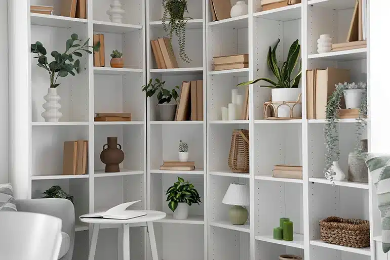 Las casas con personalidad no siguen las tendencias: siguen a quienes viven en ellas Estantería blanca decorada con libros, plantas y objetos personales