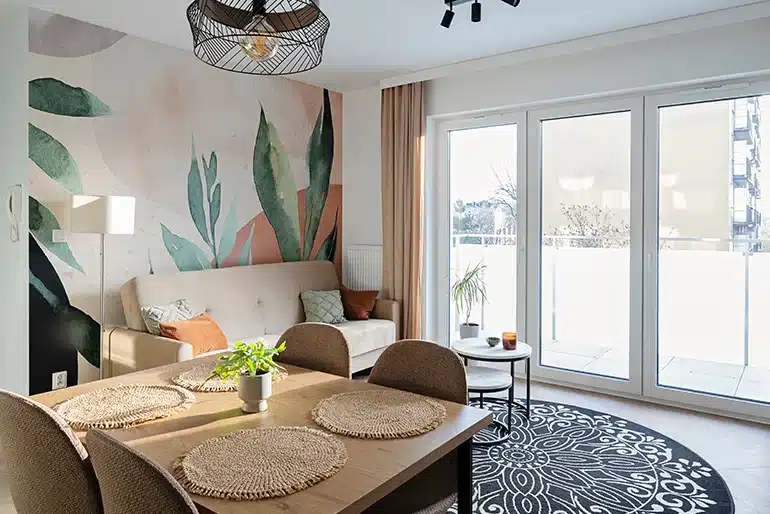Las casas con personalidad no siguen las tendencias: siguen a quienes viven en ellas Salón comedor luminoso con mural vegetal y decoración personalizada