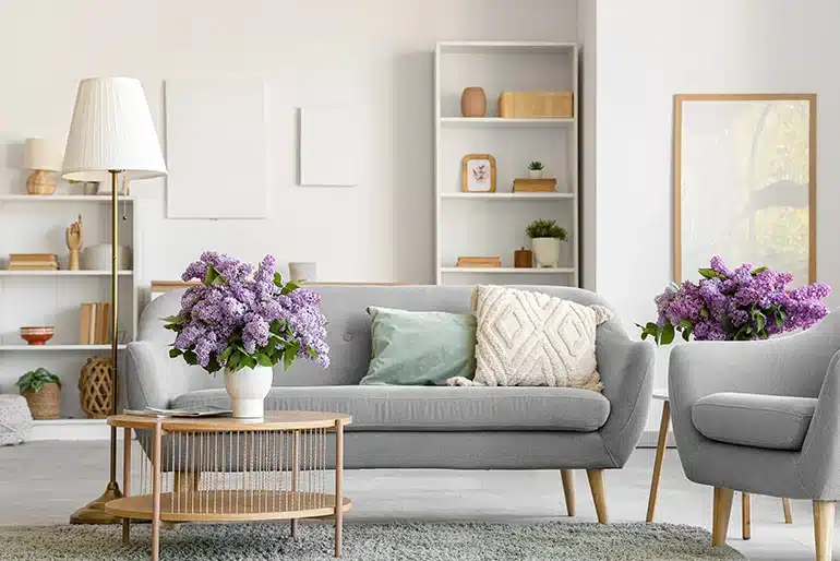 Las casas con personalidad no siguen las tendencias: siguen a quienes viven en ellas Personalidad en la decoración: Salón en tonos claros con sofá gris, flores y elementos decorativos
