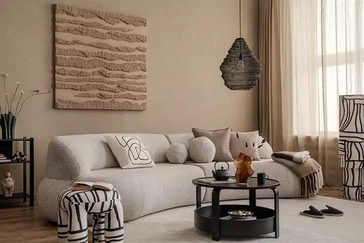 Las casas con personalidad no siguen las tendencias: siguen a quienes viven en ellas Salón acogedor en tonos neutros con sofá curvo y decoración contemporánea